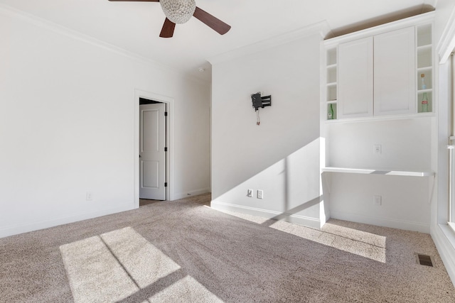 carpeted empty room with ornamental molding and ceiling fan