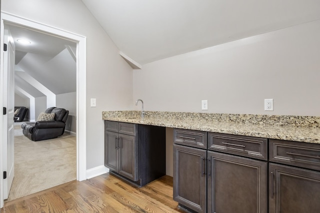 kitchen with dark brown cabinetry and lofted ceiling