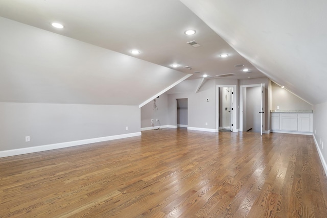 additional living space with lofted ceiling and hardwood / wood-style floors