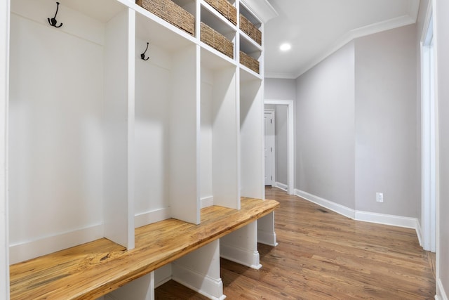 mudroom with ornamental molding and hardwood / wood-style floors