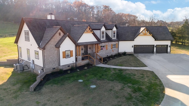 view of front of house with central AC, a garage, and a front lawn