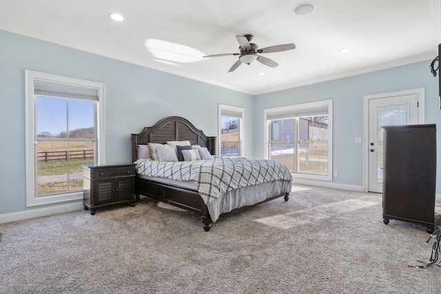 carpeted bedroom with ornamental molding and ceiling fan