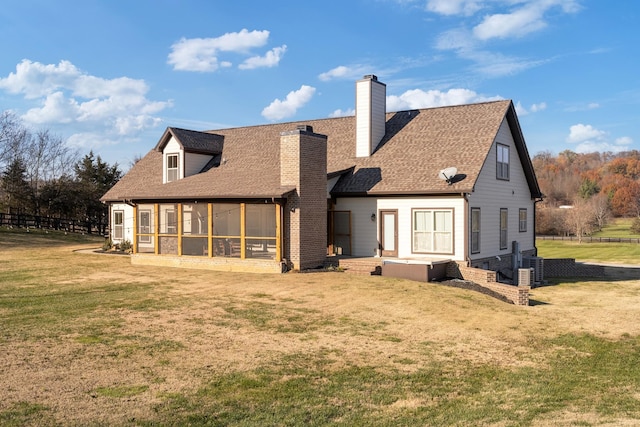 back of property featuring a yard and a sunroom