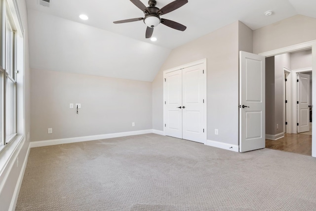 unfurnished bedroom with ceiling fan, vaulted ceiling, and carpet