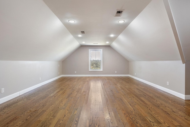 bonus room with dark hardwood / wood-style floors and vaulted ceiling