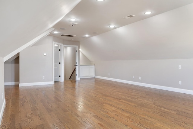 additional living space featuring lofted ceiling and hardwood / wood-style flooring