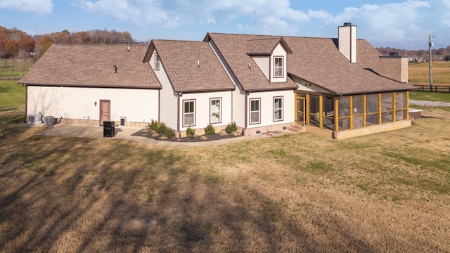 rear view of property with a patio, a sunroom, and a lawn