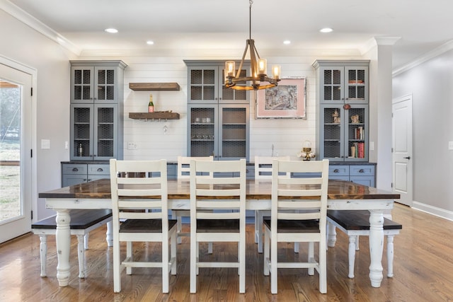 dining area featuring crown molding, wood-type flooring, and a chandelier