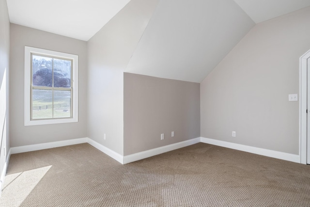 additional living space featuring light carpet and vaulted ceiling