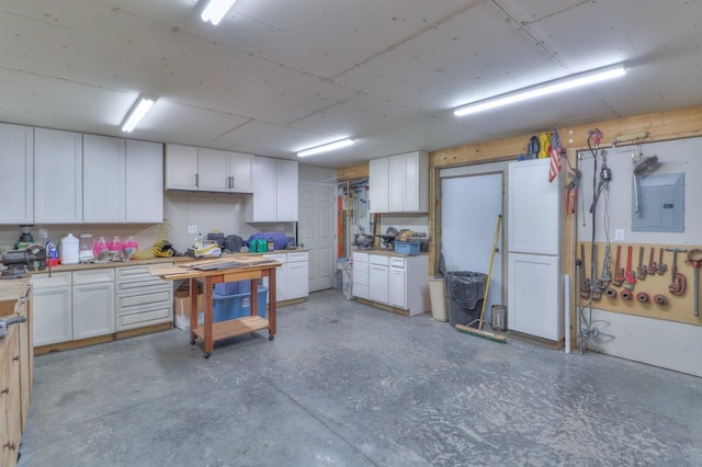 kitchen featuring electric panel and white cabinets