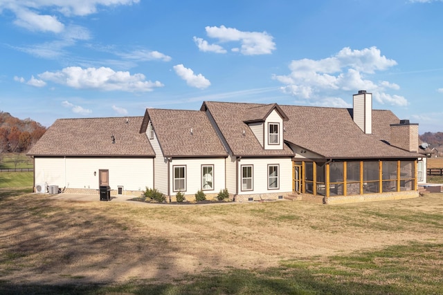 rear view of house with cooling unit, a patio, a sunroom, and a lawn