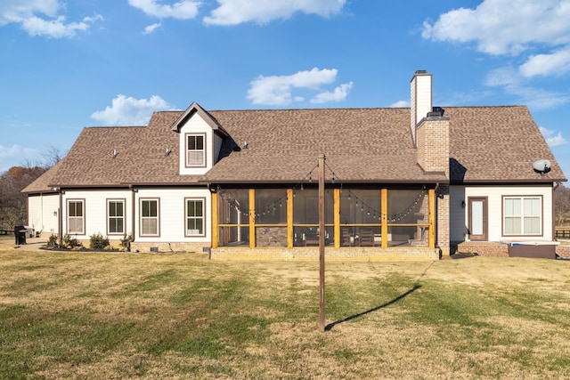 back of house featuring a sunroom and a lawn