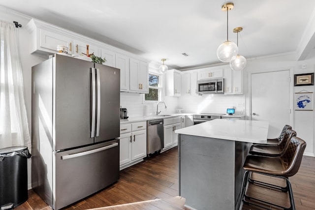 kitchen with sink, appliances with stainless steel finishes, dark hardwood / wood-style floors, white cabinets, and decorative light fixtures