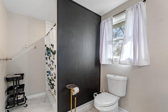 bathroom featuring curtained shower and toilet