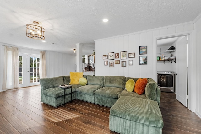 living room featuring dark wood-type flooring, a chandelier, a textured ceiling, and french doors