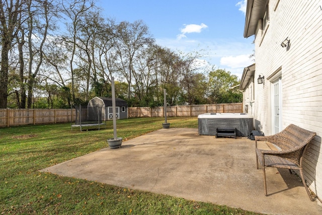 view of patio with a trampoline, a storage shed, central AC unit, and a hot tub