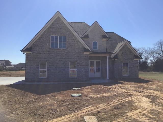 view of front of property with brick siding, stone siding, a patio, and french doors