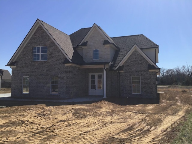 view of front facade with brick siding and french doors