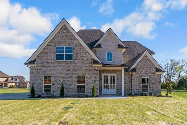 craftsman inspired home with a front yard, french doors, and brick siding