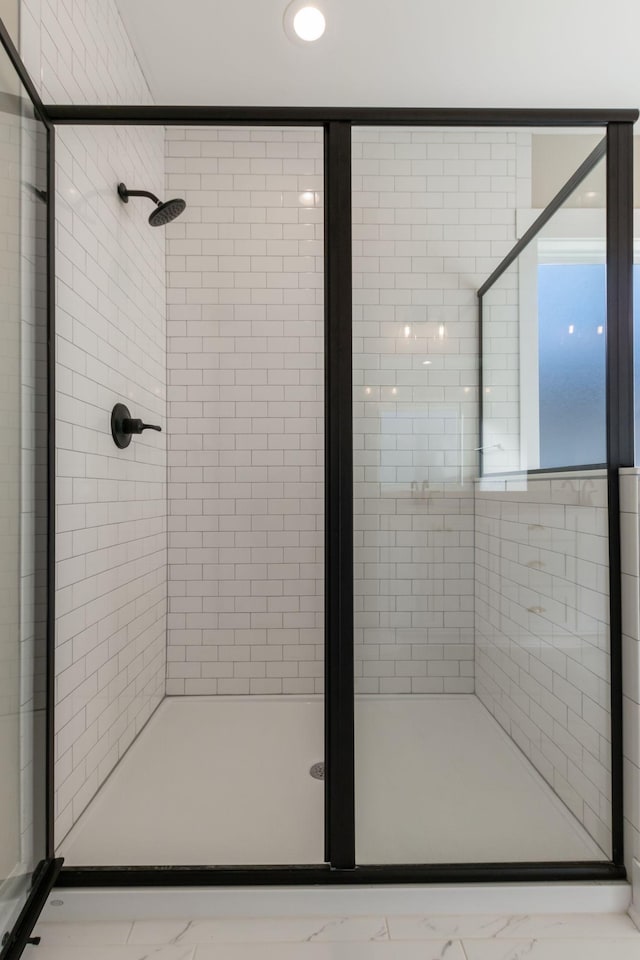 bathroom featuring a stall shower and marble finish floor