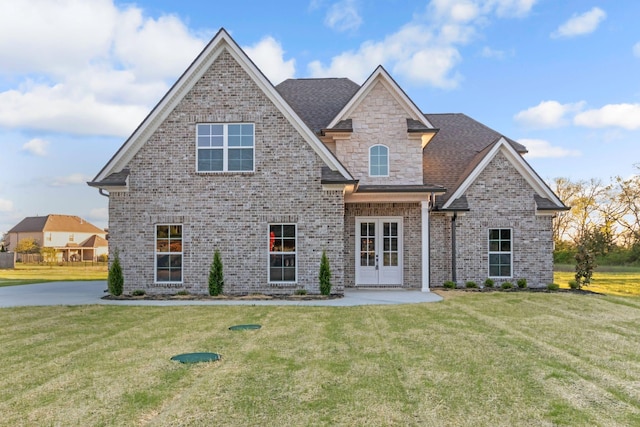 craftsman house with brick siding, french doors, and a front lawn