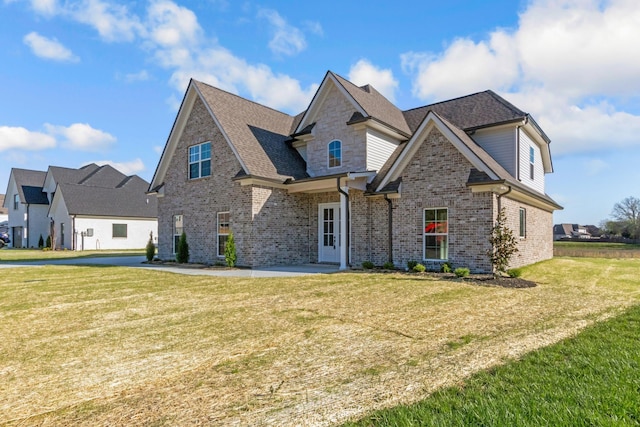 view of front of house with a front yard and brick siding