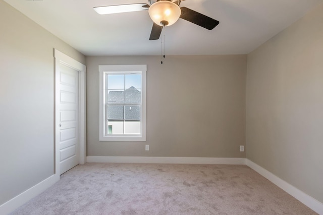 carpeted empty room with ceiling fan and baseboards