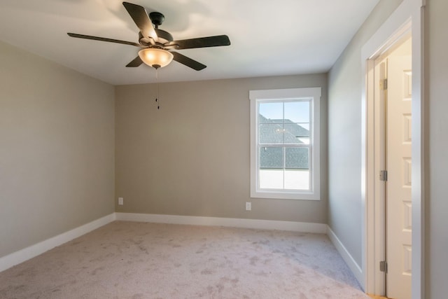 unfurnished room featuring ceiling fan, light colored carpet, and baseboards