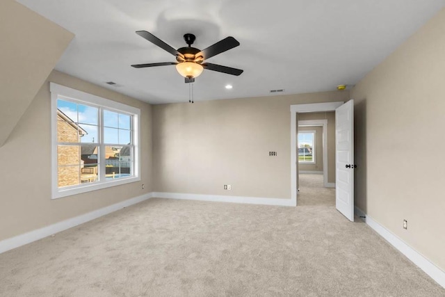 unfurnished room featuring visible vents, baseboards, ceiling fan, and light colored carpet