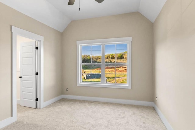 spare room featuring ceiling fan, carpet, vaulted ceiling, and baseboards