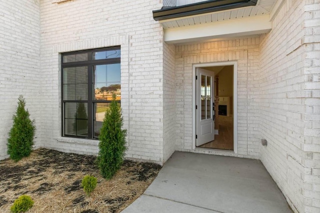 entrance to property featuring brick siding