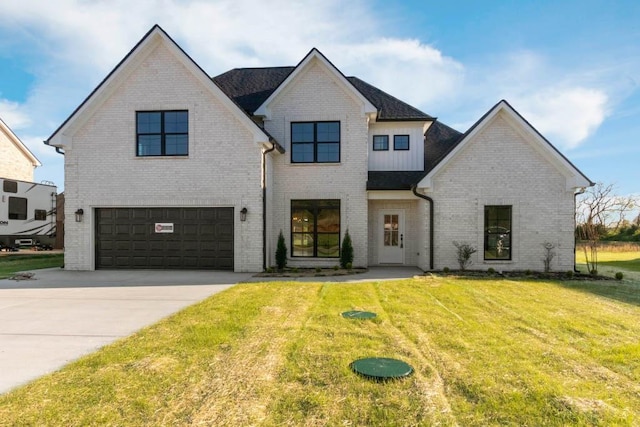 view of front facade featuring a garage, a front yard, brick siding, and driveway