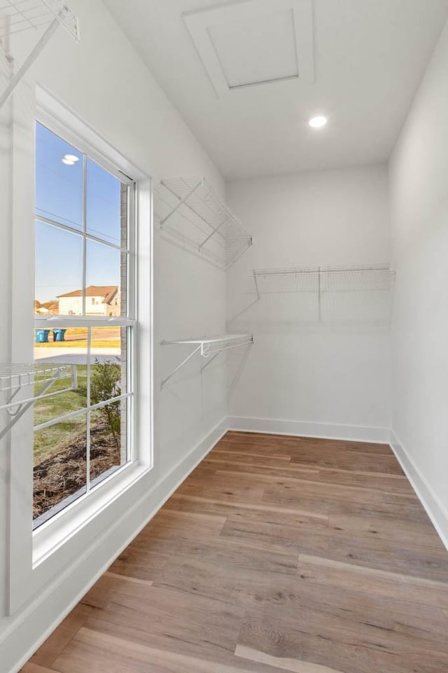 walk in closet featuring light wood-style flooring and attic access