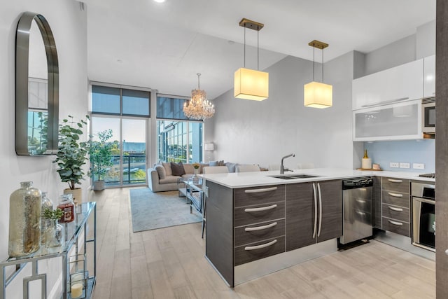 kitchen with sink, dark brown cabinets, stainless steel appliances, floor to ceiling windows, and white cabinets