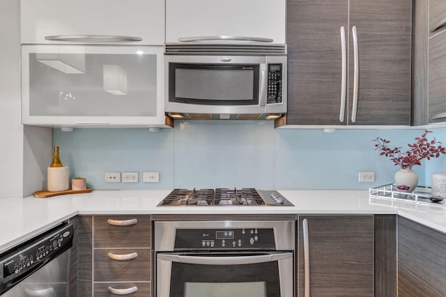 kitchen with stainless steel appliances, white cabinets, and dark brown cabinetry