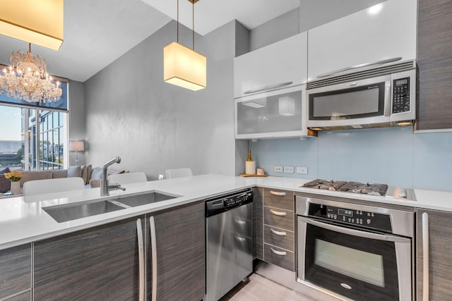 kitchen with hanging light fixtures, appliances with stainless steel finishes, dark brown cabinets, and sink