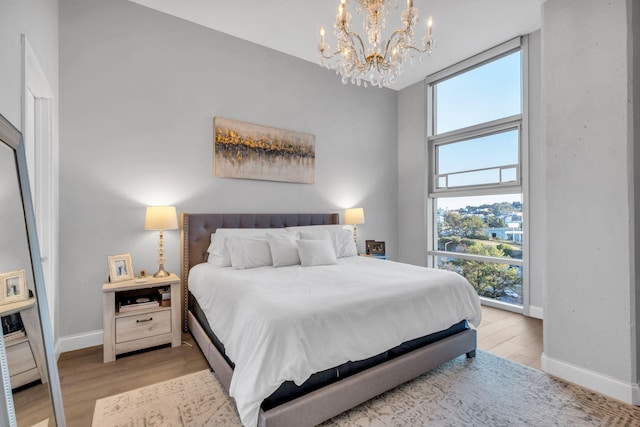 bedroom featuring a chandelier and light wood-type flooring