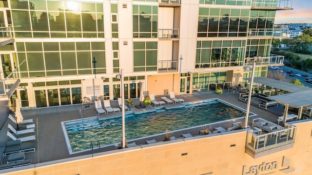 pool at dusk with a patio area