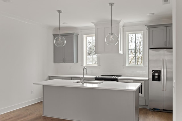 kitchen with sink, stainless steel fridge with ice dispenser, a kitchen island, and gray cabinetry