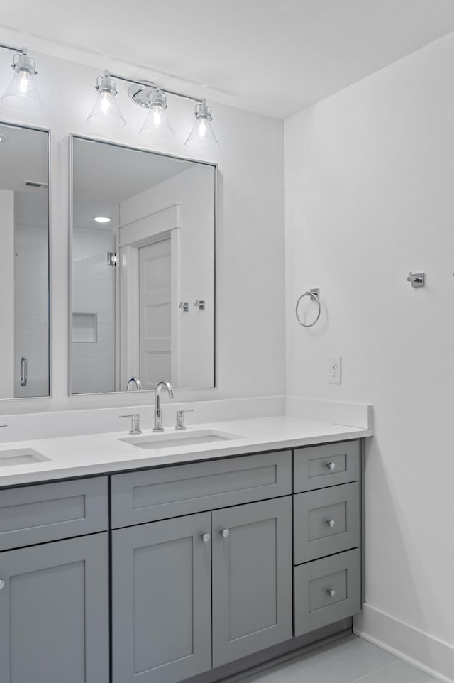 bathroom featuring tile patterned floors, vanity, and a shower with shower door