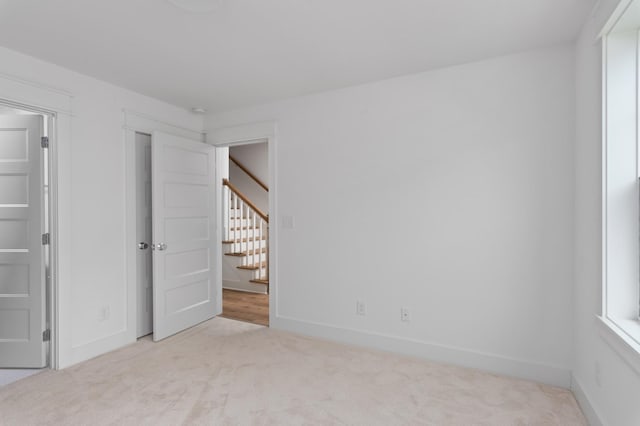 unfurnished bedroom with light colored carpet