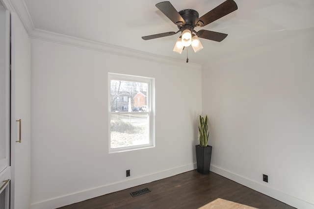 spare room featuring crown molding, dark wood-type flooring, and ceiling fan