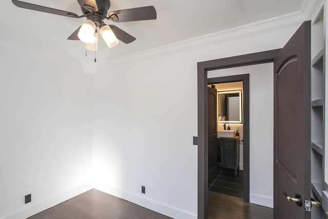 empty room featuring crown molding, ceiling fan, dark hardwood / wood-style flooring, and sink