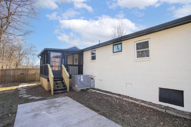 back of property with central AC unit, a patio area, and a sunroom