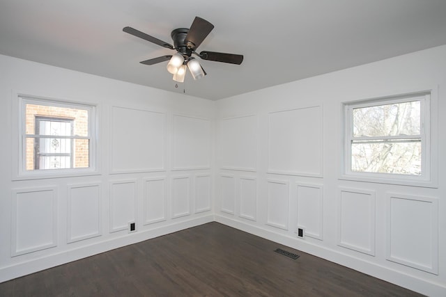 unfurnished room with ceiling fan and dark hardwood / wood-style flooring