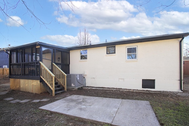 rear view of property with a patio, a sunroom, and central air condition unit