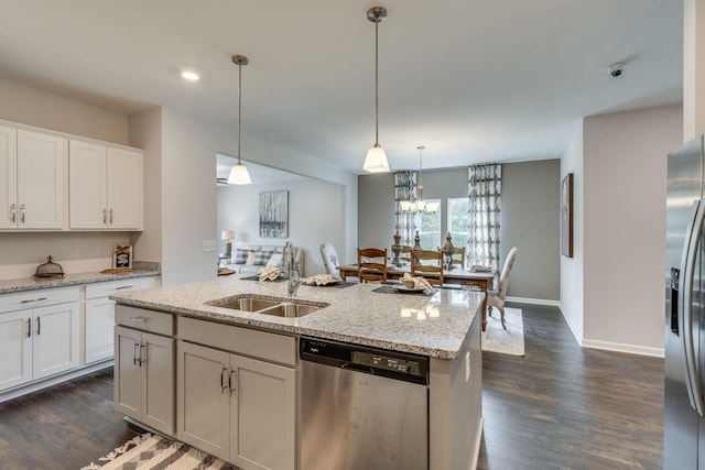 kitchen featuring appliances with stainless steel finishes, pendant lighting, white cabinetry, sink, and light stone counters