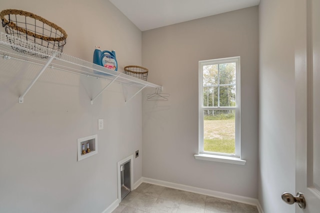 washroom with hookup for a washing machine, electric dryer hookup, and a healthy amount of sunlight