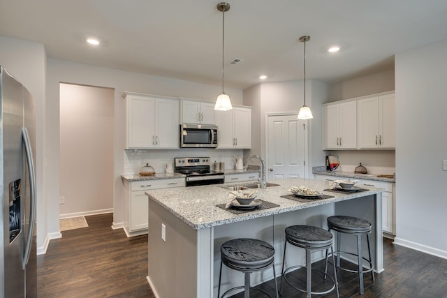 kitchen featuring pendant lighting, appliances with stainless steel finishes, sink, and white cabinets