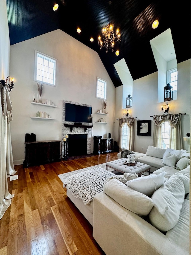 living room with hardwood / wood-style flooring, a chandelier, and a high ceiling